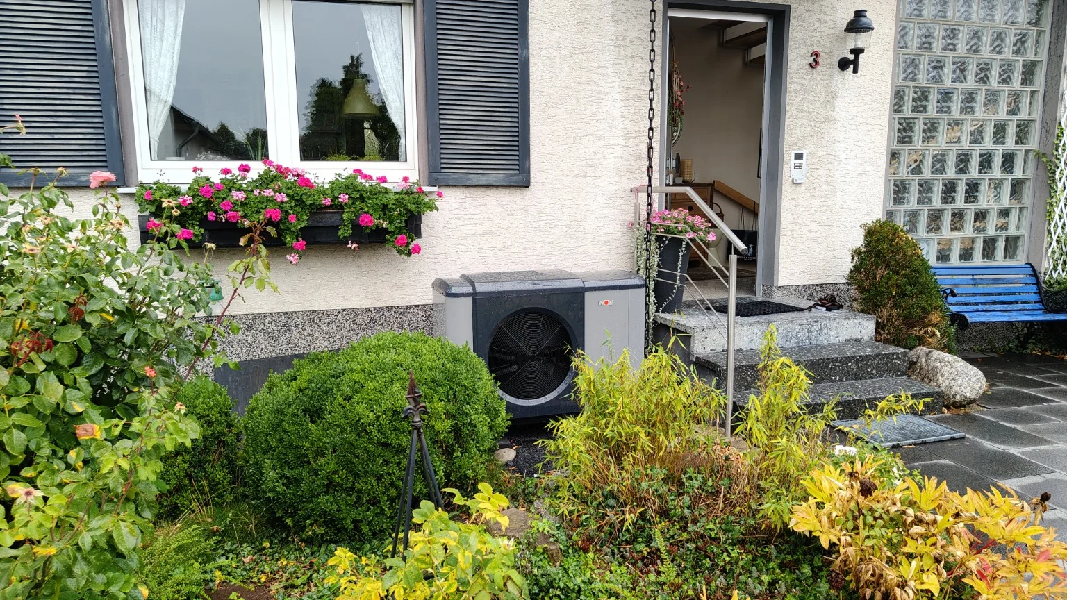Wolf Wärmepumpe im Vorgarten eines Wohnhauses